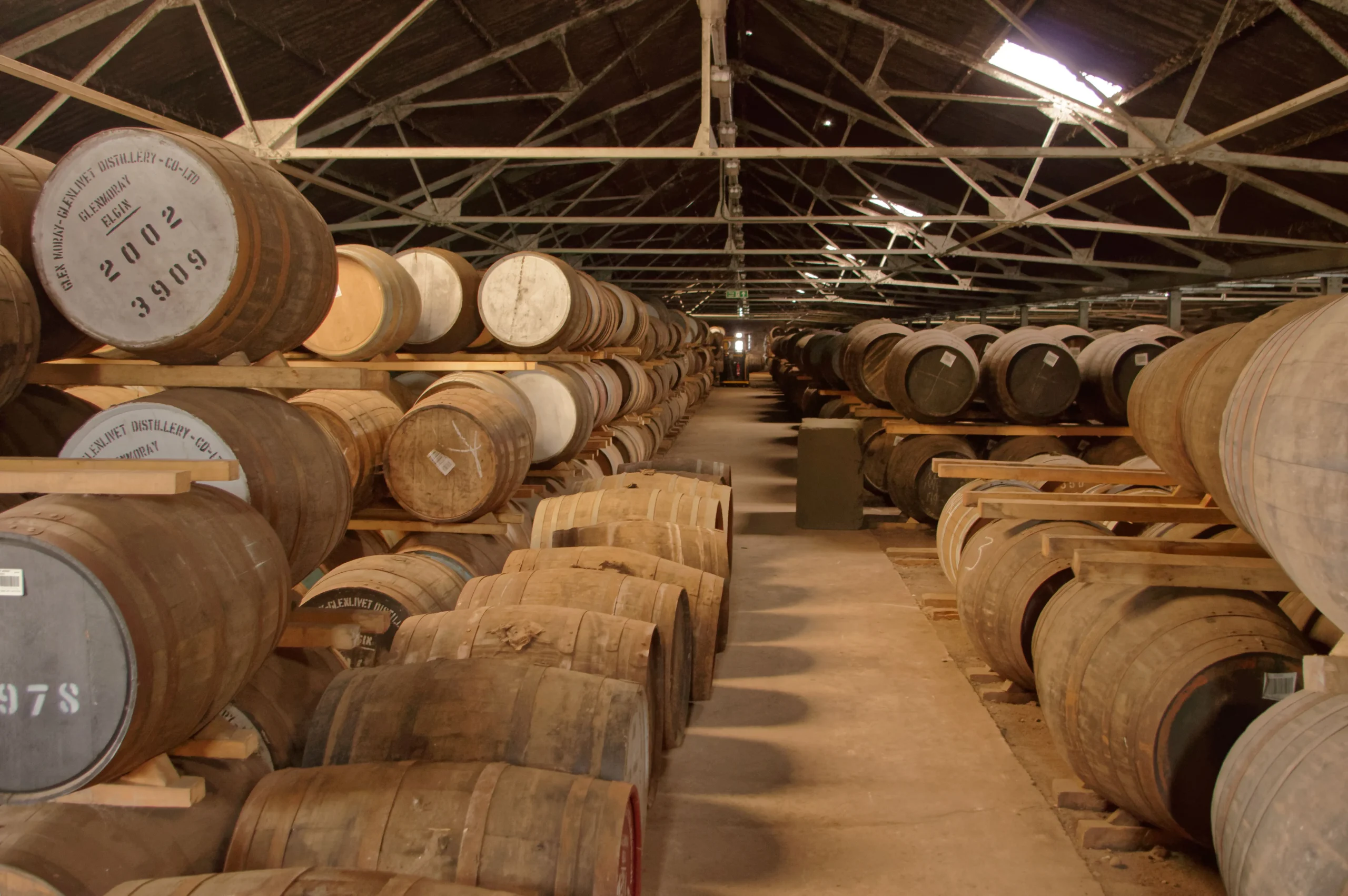 Stacked used whiskey barrels ready for sustainable reuse